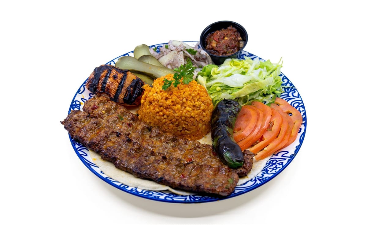 Adana kebab plate with rice, grilled vegetables and salad